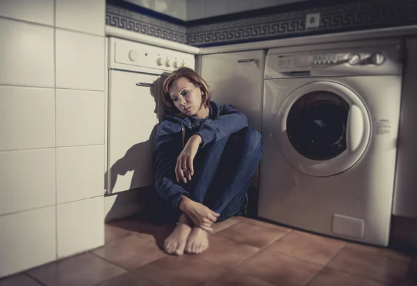 Eenzame en zieke vrouw zittend op de keukenvloer in depressie stress en verdriet — Stockfoto