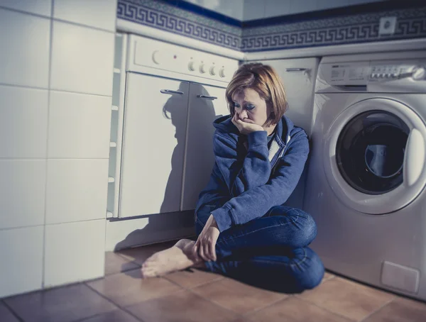 Mujer solitaria y enferma sentada en el suelo de la cocina en la depresión de estrés y tristeza — Foto de Stock