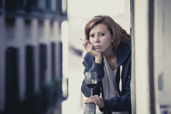 Young woman suffering depression drinking wine outdoors at the balcony — Stock Photo, Image