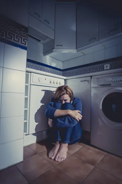 Lonely and sick woman sitting on kitchen floor in stress depression and sadness — Stock Photo, Image