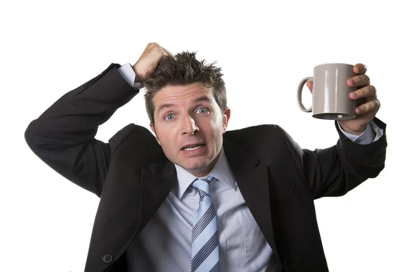 Jonge verslaafde business man in pak en stropdas lege kopje koffie angstig te houden — Stockfoto