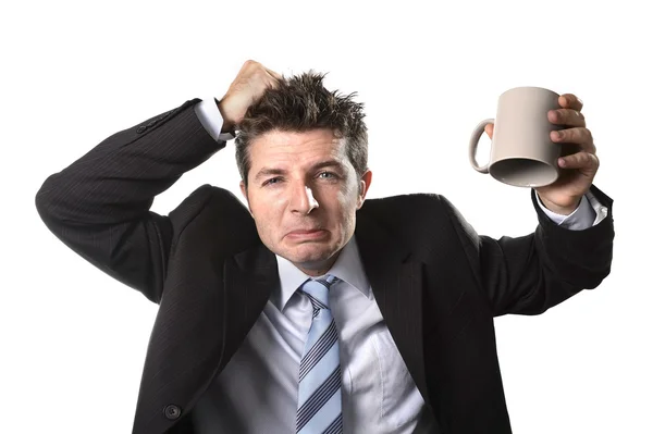 Jonge verslaafde business man in pak en stropdas lege kopje koffie angstig te houden — Stockfoto
