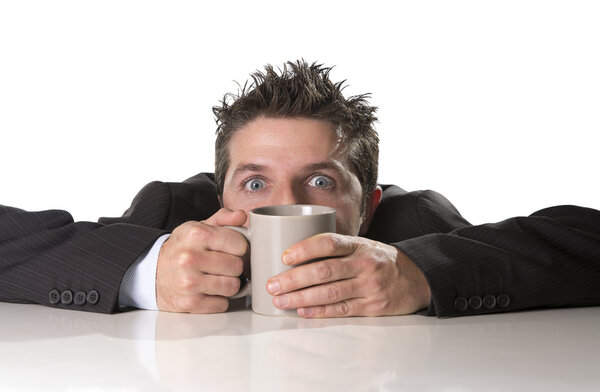 addict businessman in suit and tie holding cup of coffee as maniac in caffeine addiction