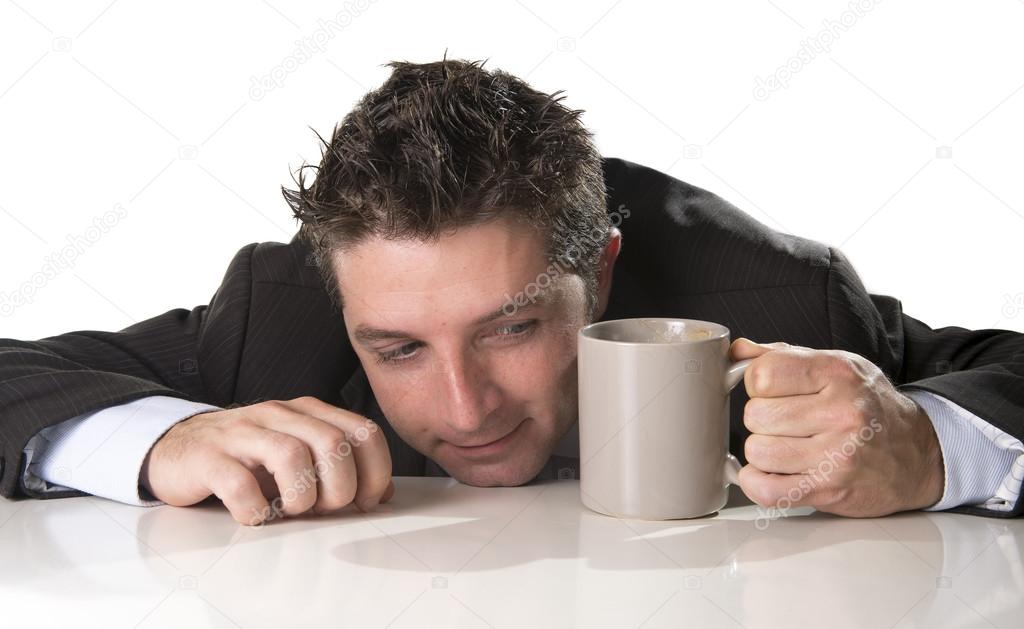 addict businessman in suit and tie holding cup of coffee as maniac in caffeine addiction