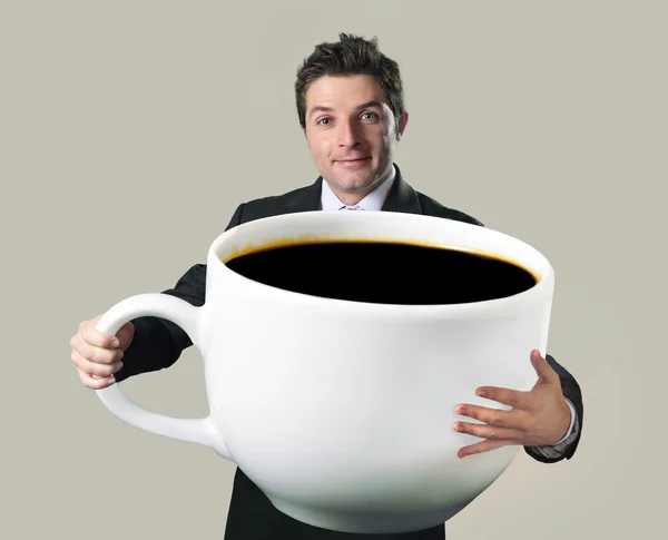 Felice uomo d'affari in possesso di divertente enorme tazza oversize di caffè nero Foto Stock Royalty Free