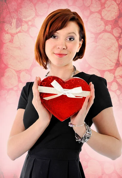 漂亮的红头发女人捧着心脏形状框周年盒子 — 图库照片