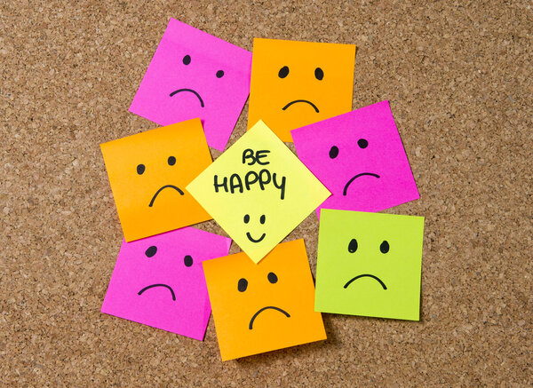 smiley post it note on corkboard in happiness versus depression concept