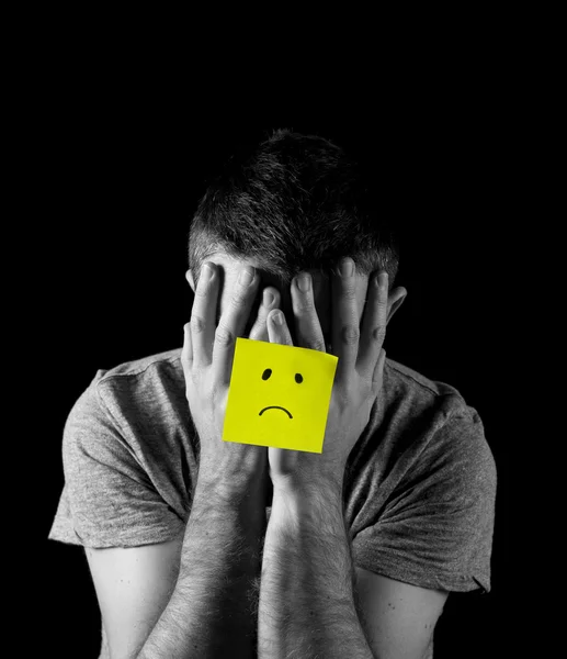 Young man suffering depression and stress alone with sad face post it note — Stock Photo, Image