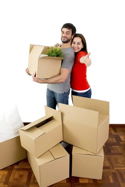 Feliz pareja moviéndose juntos en una nueva casa desempacando cajas de cartón —  Fotos de Stock