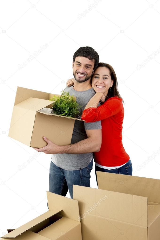 happy couple moving together in a new house unpacking cardboard boxes 