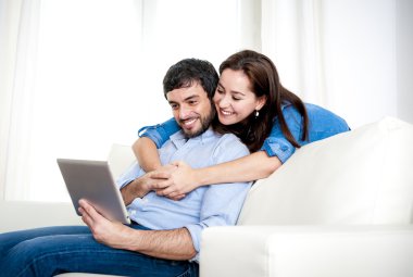 evde kanepede genç mutlu çift dijital tablet bilgisayar kullanarak zevk