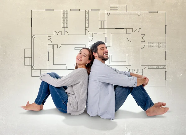 Pareja joven soñando e imaginando su nueva casa en concepto de bienes raíces — Foto de Stock