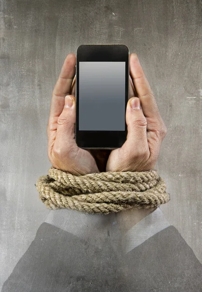 Handen van zakenman verslaafd aan mobiele telefoon touw bond polsen in smartphone internet verslaving — Stockfoto