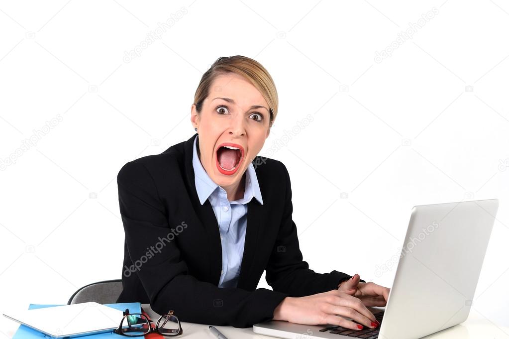 Businesswoman sitting at office desk working with laptop in stress looking upset