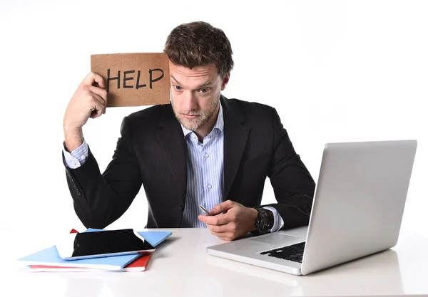 Atractivo hombre de negocios que trabaja en el estrés en la computadora sosteniendo ayuda cartulina signo — Foto de Stock