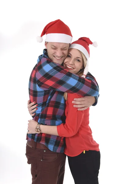 Natale giovane bella coppia in Babbo Natale cappelli in amore sorridente felice insieme abbracciarsi dolce — Foto Stock