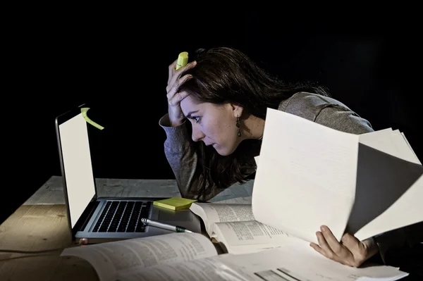 Joven estudiante universitaria desesperada chica en estrés para el examen de estudiar con libros y computadora portátil tarde en la noche —  Fotos de Stock