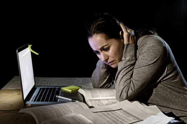 Joven estudiante universitaria desesperada chica en estrés para el examen de estudiar con libros y computadora portátil tarde en la noche —  Fotos de Stock