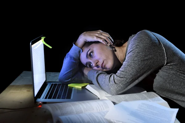 Joven estudiante universitaria desesperada chica en estrés para el examen de estudiar con libros y computadora portátil tarde en la noche —  Fotos de Stock