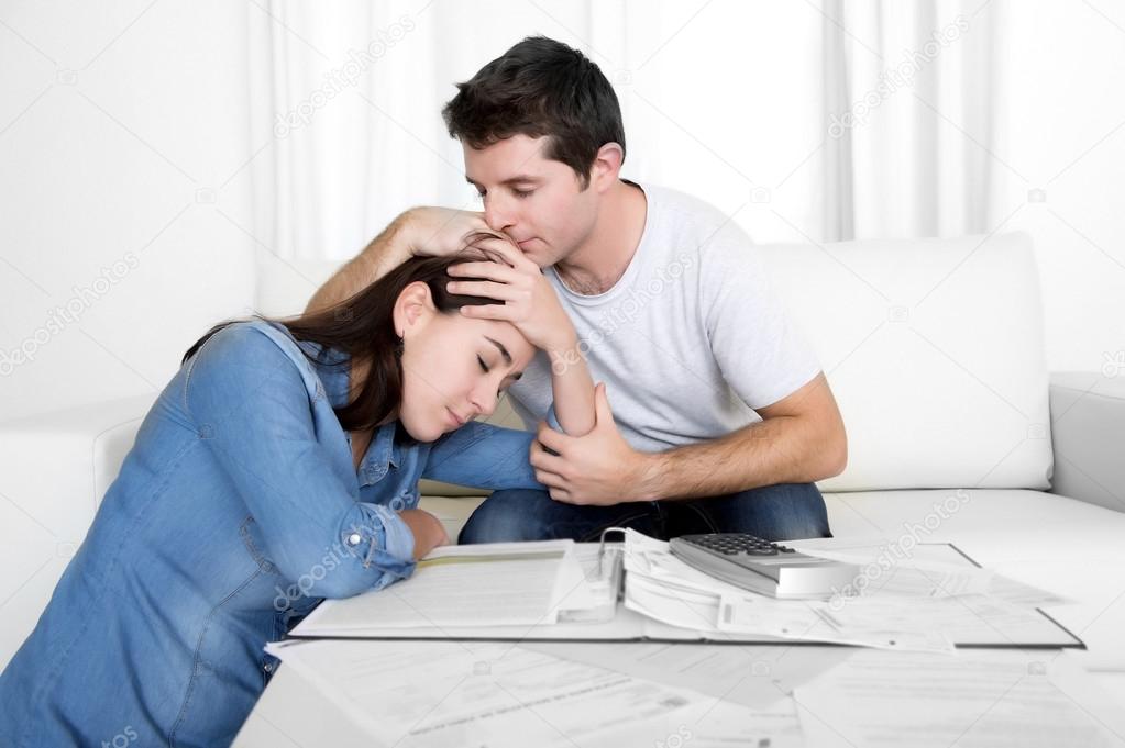 Young couple worried home in stress husband comforting wife in financial problems