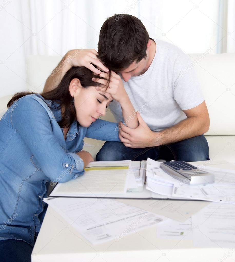 Young couple worried home in stress husband comforting wife in financial problems