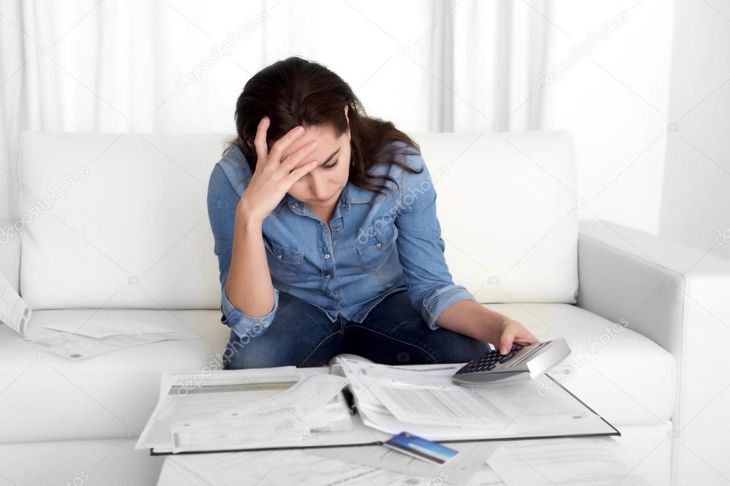 young woman worried at home in stress accounting bank papers with calculator