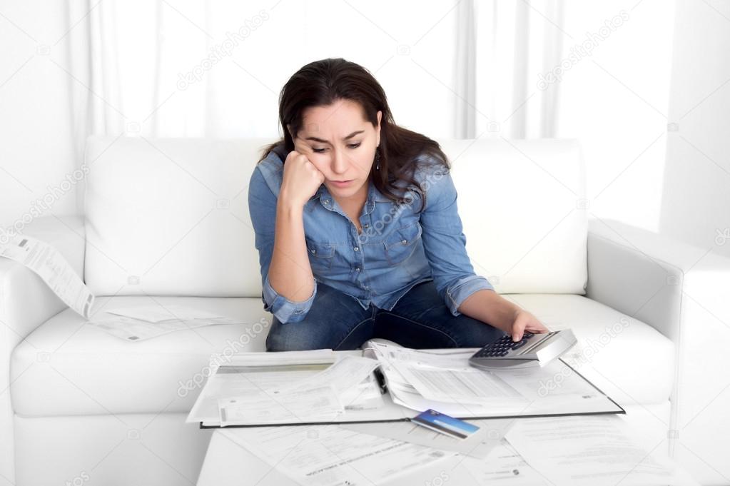 young woman worried at home in stress accounting bank papers with calculator