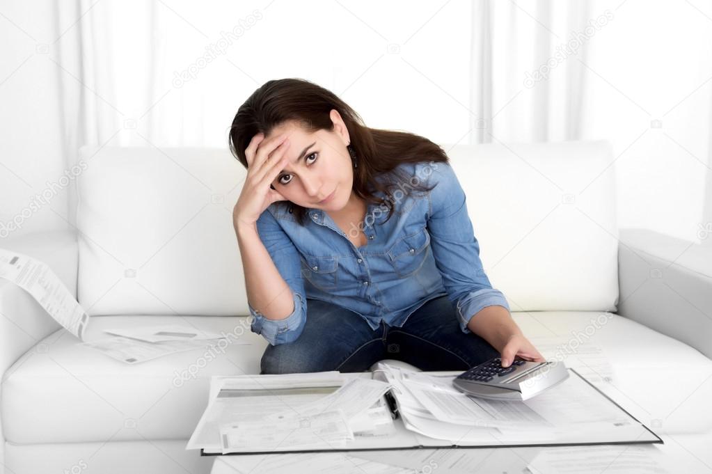 young woman worried at home in stress accounting bank papers with calculator