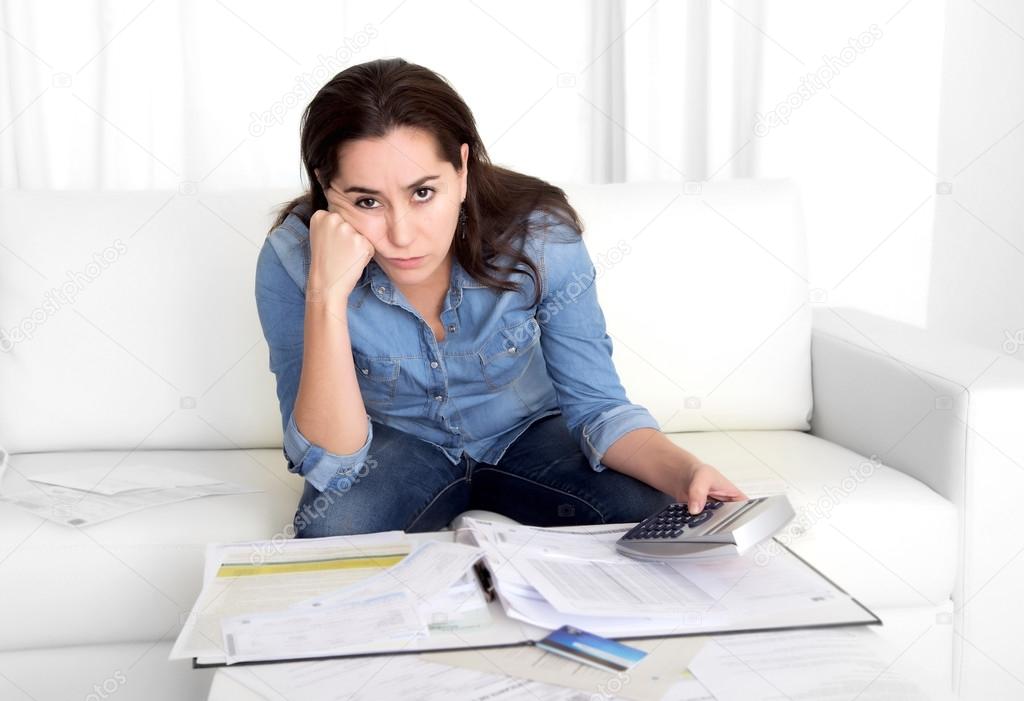 young woman worried at home in stress accounting bank papers with calculator