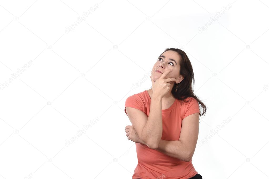 Hispanic woman thoughtful and pensive thinking and dreaming looking up on copy space