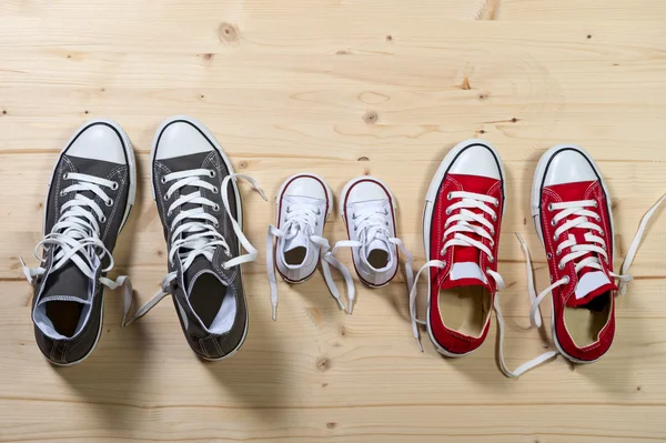 Three pair of shoes in father big, mother medium and son or daughter small kid size in family togetherness concept — Stock Photo, Image