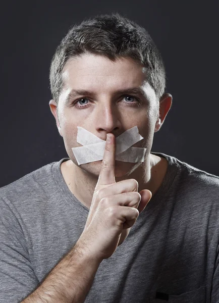 Attrayant jeune homme avec bouche scellée sur du ruban adhésif pour l'empêcher de parler — Photo