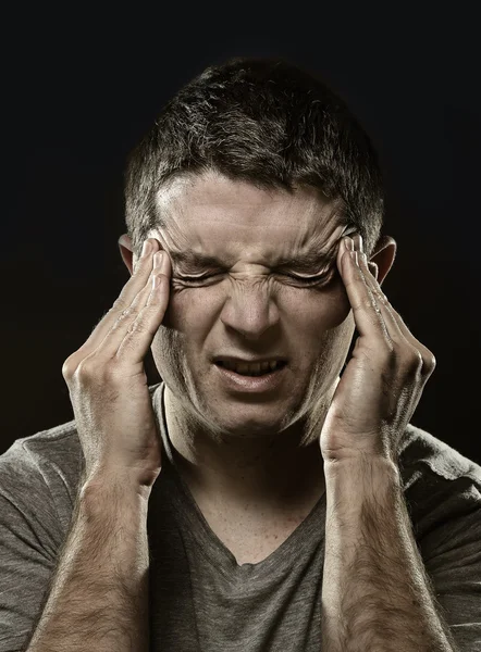 Homme souffrant de migraine et de maux de tête dans une douleur désespérée se sentir malade avec les mains sur le tempo — Photo