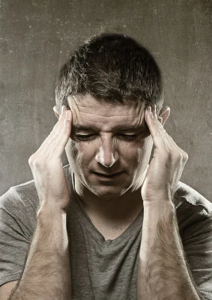 Man suffering migraine and headache in desperate pain feeling sick with hands on tempo — Stock Photo, Image