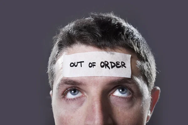 Young man with blue eyes and tape text out of order on forehead in dry empty mind — Stock Photo, Image