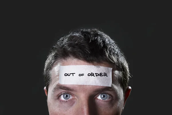 Young man with blue eyes and tape text out of order on forehead in dry empty mind — Stock Photo, Image