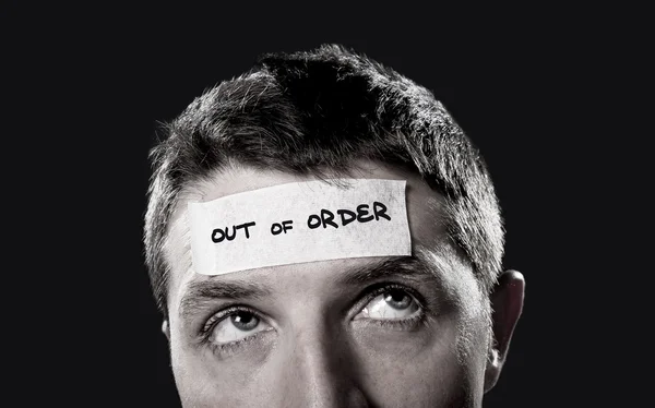 Young man with blue eyes and tape text out of order on forehead in dry empty mind — Stock Photo, Image