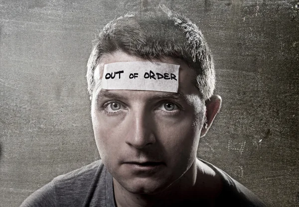 Young man with blue eyes and tape text out of order on forehead in dry empty mind — Stock Photo, Image