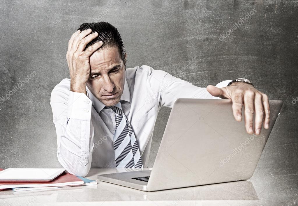 Desperate senior businessman in crisis working on computer at office