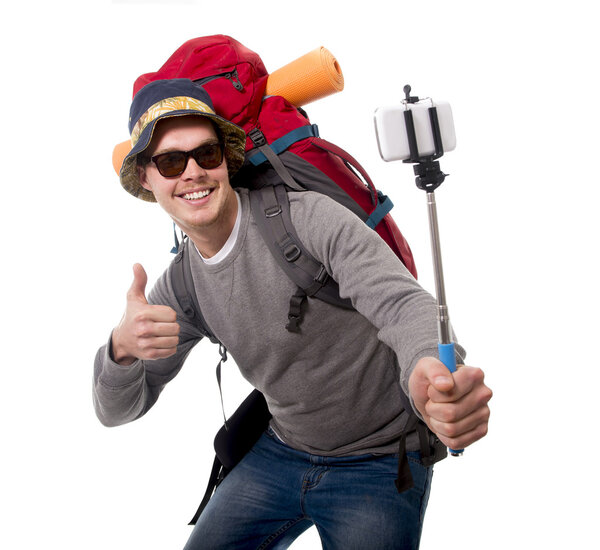 young traveler backpacker taking selfie photo with stick carrying backpack ready for adventure