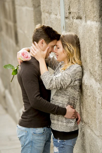 Hermosa pareja enamorada besándose en callejón celebrando San Valentín —  Fotos de Stock