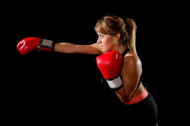 Genç zinde ve güçlü çekici boksör kız agresif atma mücadele kırmızı boks eldivenli kızgın hissediyor spor olarak eğitim çalışma yumruk