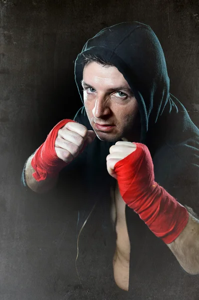 Man in boxing hoodie jumper with hood on head with wrapped hands wrists ready for fighting — Stock Photo, Image