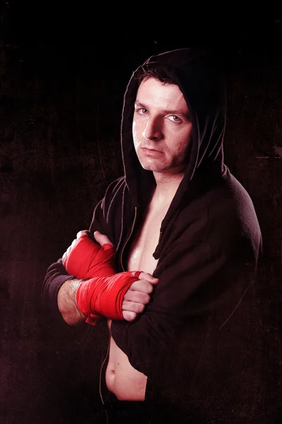 Man in boxing hoodie jumper with hood on head with wrapped hands wrists ready to combat — Stock Photo, Image