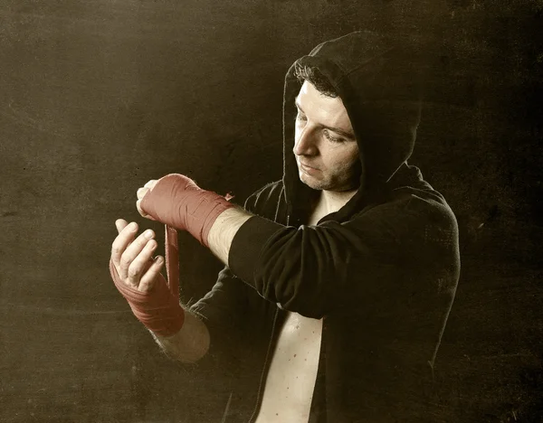 Uomo in boxe felpa con cappuccio con cappuccio che avvolge i polsi delle mani prima dell'allenamento in palestra — Foto Stock