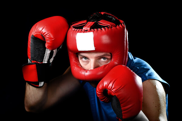 Amateur boxer man fighting with red boxing gloves and headgear protection