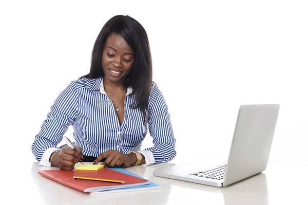 Attractive and efficient black ethnicity woman writing on notepad at office computer laptop desk — Stock Photo, Image