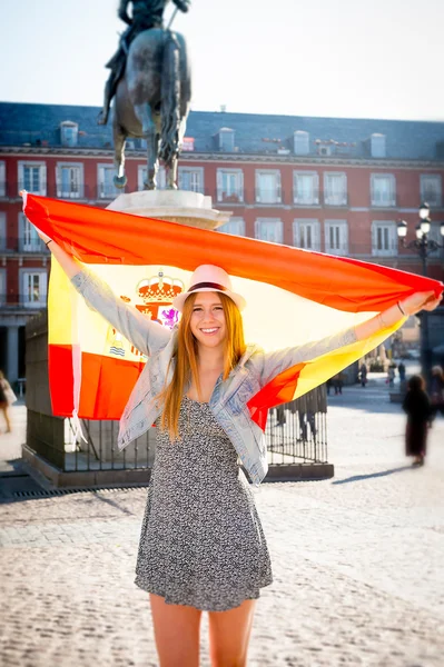 Giovane felice scambio attraente studentessa divertirsi in città visitando Madrid città che mostra la Spagna bandiera — Foto Stock