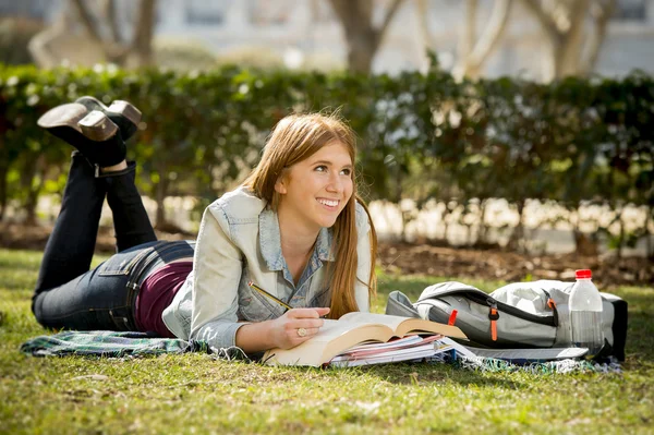 Ung vacker student tjej på campus park gräs med böcker studera glad förberedande examen utbildning koncept — Stockfoto