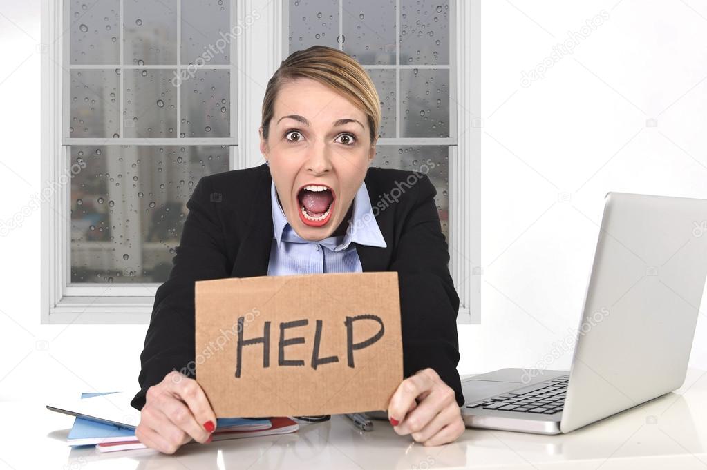 Young stressed businesswoman holding help sign overworked at office computer